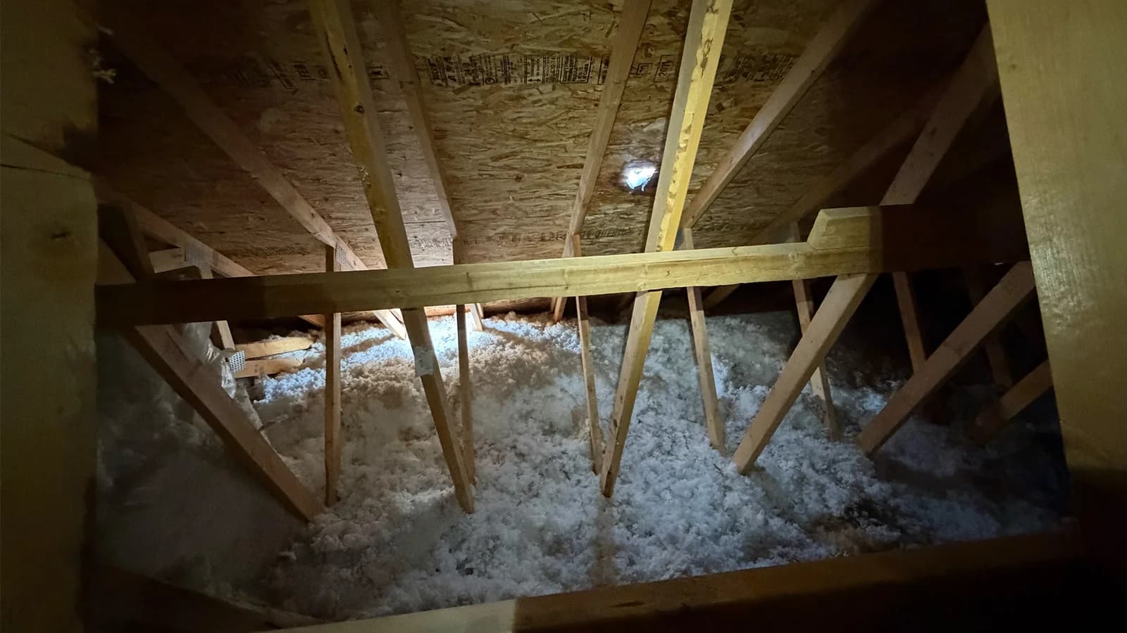 Winter attic inspection identifying condensation and ceiling stains in a Cochrane home
