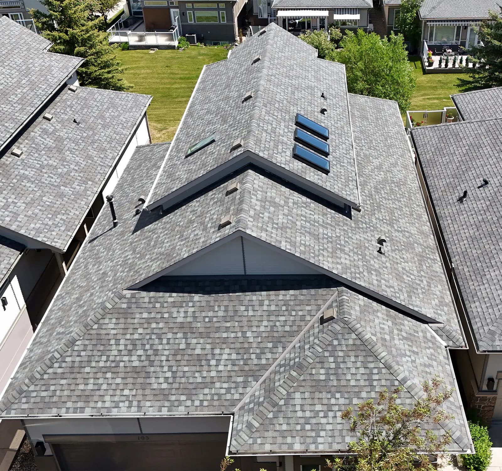 Aerial view of a Cochrane Alberta home roof with skylights installed by Sure West Roofing